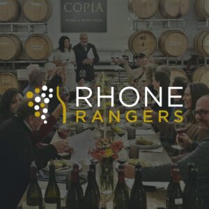 a group of people around a table with wine bottles